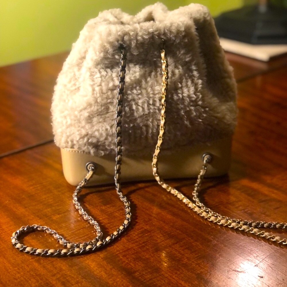Chanel, shearling back pack with gold and silver alternating chains. Natural